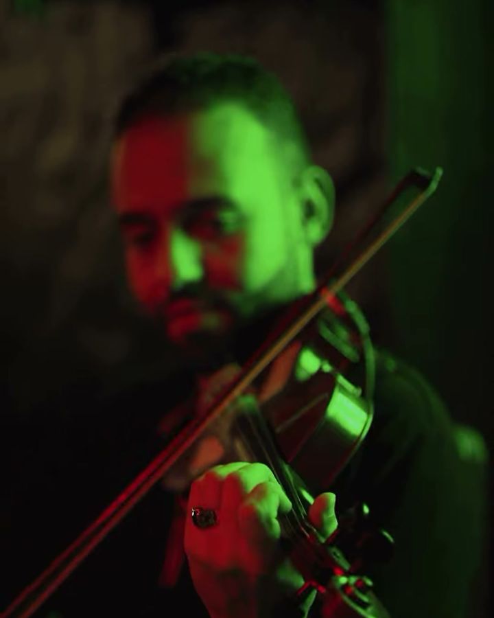 Le violoniste de l’orchestre sous la lumière verte de la scène